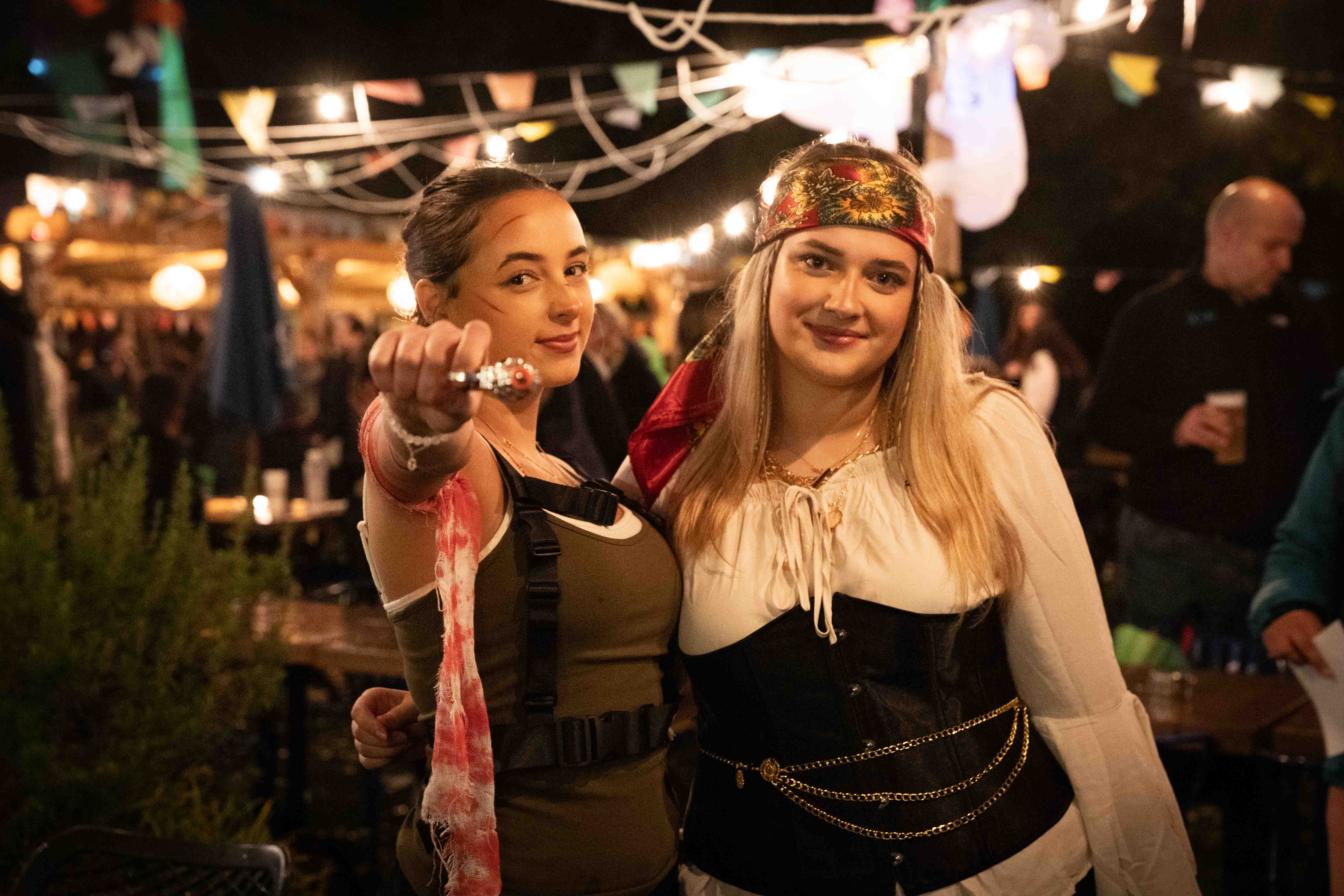 Two women in Halloween pirate costumes at outdoor venue