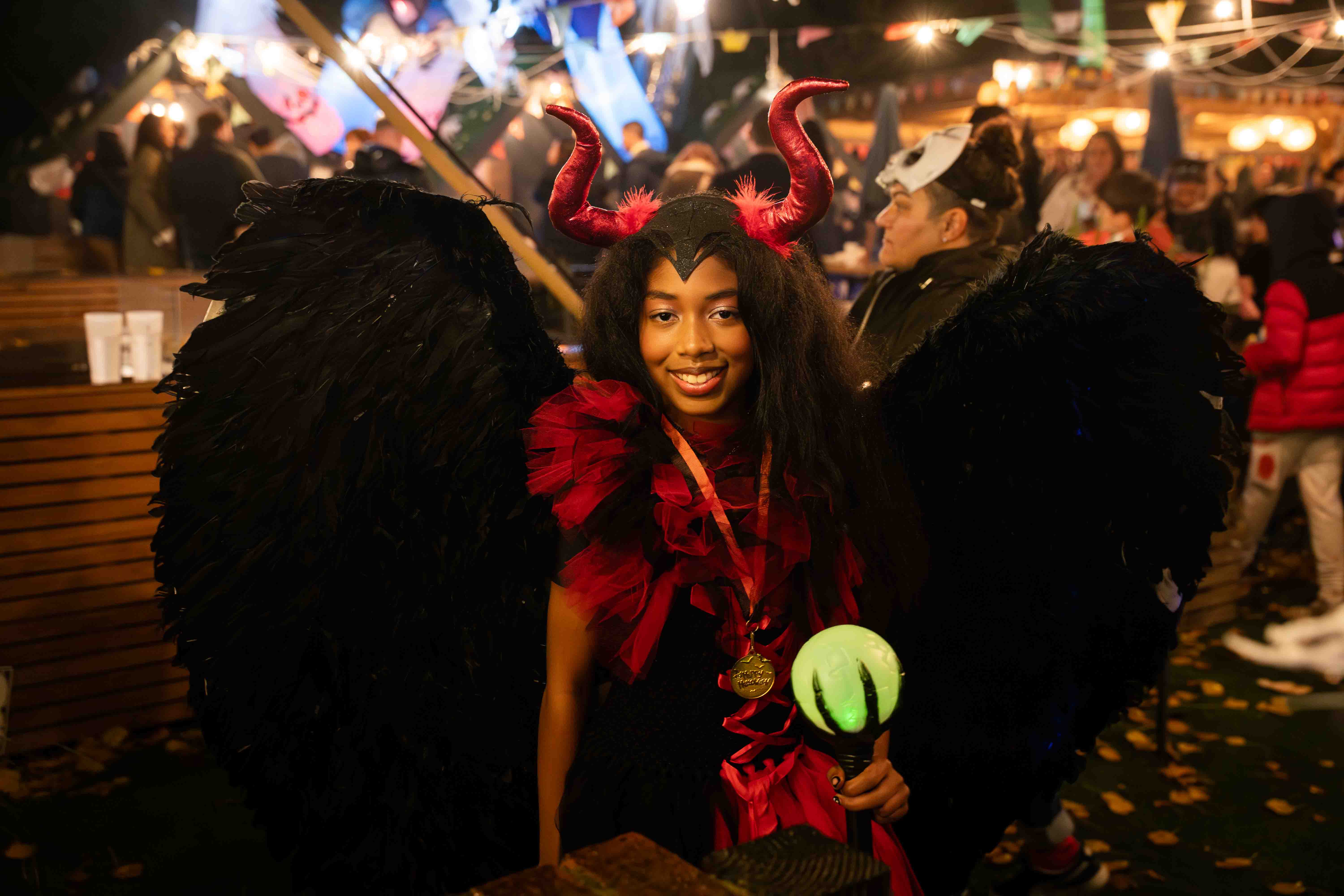 Person in elaborate devil costume with large black wings