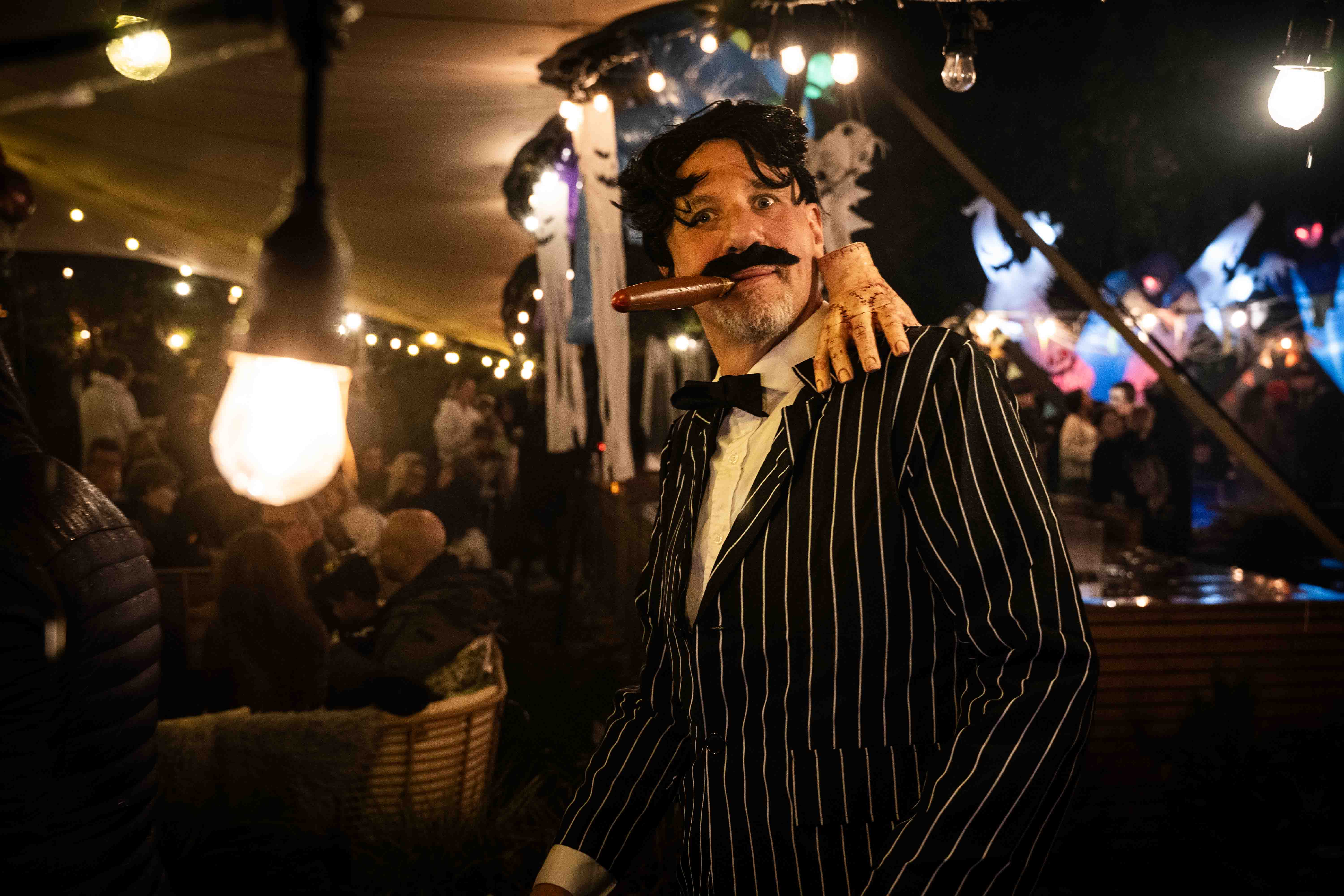 Man dressed in 1920s gangster costume with pinstripe suit